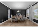 Elegant dining room with dark accent wall, wood floors, chandelier and bright windows at 1325 Bermuda Grass Dr., Myrtle Beach, SC 29579