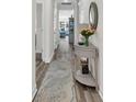 Bright hallway featuring hardwood floors, an elegant accent table, and a glimpse into the living area at 1340 Jolly Roger Dr., North Myrtle Beach, SC 29582