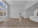 Spacious living area with tall ceilings, lots of natural light, and sleek wood floors at 1533 Coastal Cove Ln, Calabash, NC 28467