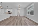 Bright living room features wood-look flooring, recessed lighting, and a large window with backyard views at 1549 Coastal Cove Ln, Calabash, NC 28467