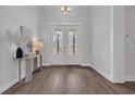 Elegant foyer with hardwood floors, white trim, stylish lighting, and French doors at 1940 Indigo Cove Ln, Calabash, NC 28467
