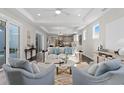 Bright living room boasts tray ceiling, hardwood floors, and seamless open-concept layout at 1946 Indigo Cove Ln, Calabash, NC 28467