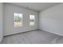 A bright bedroom offers natural light from two windows and has neutral carpet and paint at 200 Lister St, Conway, SC 29526