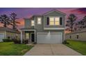 Two-story home featuring a garage, black door, and well-lit exterior at 2059 Borgata Loop, Longs, SC 29568