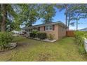 Well-maintained lawn surrounds brick home with manicured landscaping and classic shutters at 2519 Reta St., Conway, SC 29526