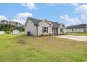 Beautiful exterior view of the home showcasing the lawn, siding, and storage shed in the backyard at 2521 Wise Rd., Conway, SC 29526