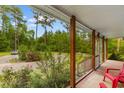 Inviting screened porch with wood columns and railings, offering a relaxing outdoor space with backyard views at 2650 Highway 554, Loris, SC 29569