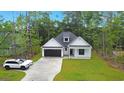Attractive home with a large driveway, well-maintained lawn, and modern black and white accents at 4120 Whatuthink Rd., Myrtle Beach, SC 29588