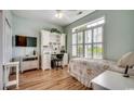 Bright bedroom features a large window with shutters, a desk, and hardwood floors at 4294 Rivergate Ln., Little River, SC 29566