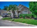 Charming home with stone accents, a landscaped yard, and a welcoming entrance with a palm tree at 4294 Rivergate Ln., Little River, SC 29566