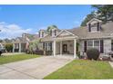 View of multiple townhomes with well-kept lawns, covered carports, and brick details under a blue sky at 511 Colonial Trace Dr. # 7-C, Longs, SC 29568
