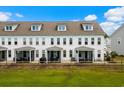 Townhome rear view featuring screened porches overlooking a spacious lawn and wooded area at 5127 Double Eagle Way # 11, North Myrtle Beach, SC 29582