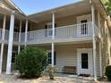 Charming condo exterior showcasing private balconies with white railings and a bench in the courtyard at 5206 Sweetwater Blvd. # 5206, Murrells Inlet, SC 29576