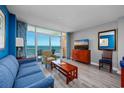 Bright living room with ocean views, modern furniture, and a sliding glass door to a balcony at 5300 N Ocean Blvd. # 1208, Myrtle Beach, SC 29572