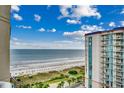 Gorgeous ocean view from the balcony, overlooking the beach with palm trees and resort amenities at 5300 N Ocean Blvd. N # 1120, Myrtle Beach, SC 29577