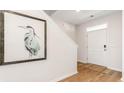Bright entryway with hardwood floors, white door, and stylish heron artwork on the wall at 586 Strawberry Field Way, Galivants Ferry, SC 29544