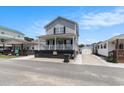 Quaint two-story house boasting a welcoming porch, manicured surroundings, and proximity to neighboring homes at 6001-1454 S Kings Hwy., Myrtle Beach, SC 29575