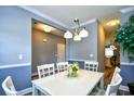 Well-lit dining room showcasing a white dining table, chandelier, wainscoting, and view to the kitchen at 6172 Catalina Dr. # 515, North Myrtle Beach, SC 29582