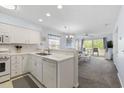 Open-concept kitchen with white cabinets, modern appliances, and a view into the living room at 633 Waterway Village Blvd # 11D, Myrtle Beach, SC 29579