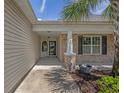 Inviting front porch with brick columns, garden area, and tasteful landscaping, offering a warm welcome at 691 Sandberg St., Surfside Beach, SC 29575