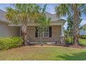 Lovely brick exterior with manicured front yard, featuring palm trees, green lawn and decorative shrubs at 691 Sandberg St., Surfside Beach, SC 29575