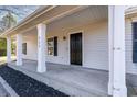 Inviting front porch with white columns, a black front door, and manicured landscaping offering curb appeal at 822 Highway 90, Conway, SC 29526