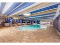 Beautifully designed indoor pool area with tile flooring, striped ceiling, and lounge chairs at 1105 S Ocean Blvd. # 814, Myrtle Beach, SC 29577