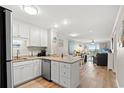 Open-concept kitchen with white cabinetry, granite counters, and views into the living area at 1310 N Waccamaw Dr. # 204, Garden City Beach, SC 29576