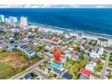 Aerial view of a coastal community, pinpointing a blue beach house near the ocean at 163 Cypress Ave., Murrells Inlet, SC 29576