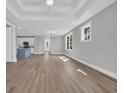 Open-concept living space with hardwood floors, recessed lighting, and a view of the kitchen and backyard at 1929 Indigo Cove Ln, Calabash, NC 28467