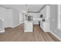 Well-lit kitchen with white cabinets, stainless steel appliances, and an island with bar seating at 1961 Indigo Cove Ln, Calabash, NC 28467