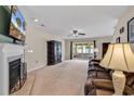 Cozy living room with a fireplace, ceiling fan, and sliding glass doors to a sunroom at 2017 Chadbury Ln., Myrtle Beach, SC 29588