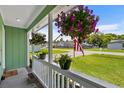 Inviting porch featuring hanging flower baskets and potted plants, creating a warm welcome at 202 Millstone Dr., Myrtle Beach, SC 29588
