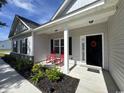 Inviting porch with red rocking chairs and a wreath on the front door adding charm to the home's entrance at 206 N Levee Dr., Georgetown, SC 29440