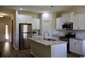 Modern kitchen with white cabinets, stainless steel appliances, granite countertops, and a central island with a sink at 206 N Levee Dr., Georgetown, SC 29440
