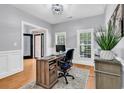 Bright home office with wood floors, a large desk, and natural light from multiple windows at 2441 Hunters Trail, Myrtle Beach, SC 29588