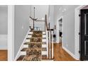 A carpeted staircase with white banisters, leading to the upper level with lots of natural light at 2441 Hunters Trail, Myrtle Beach, SC 29588