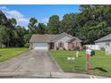 Charming single-story home with a brick accent wall, red shutters, landscaped front yard, and an attached garage at 271 Sienna Dr., Little River, SC 29566