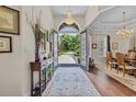 Inviting foyer with chandelier lighting, wood floors, and views to the dining and front yard at 290 Dornoch Dr., Pawleys Island, SC 29585