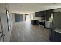 Open-concept kitchen featuring stainless appliances, dark cabinets, and wood-look flooring at 400 Cessna St, Myrtle Beach, SC 29577