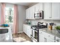 Bright kitchen featuring white cabinets, stainless steel appliances, and granite countertops at 404 Falling Leaf Loop, Myrtle Beach, SC 29588