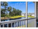 Scenic view from screened-in porch overlooking serene pond and lush greenery at 4933 Crab Pond Ct. # 201, Myrtle Beach, SC 29579