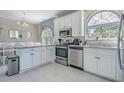 Bright kitchen featuring stainless steel appliances, white cabinetry, granite countertops, and arched windows at 500 23Rd Ave. S, North Myrtle Beach, SC 29582