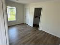 Bright bedroom with wood floors, trim, a window, and access to a bathroom at 512 King Air Ct, Myrtle Beach, SC 29577