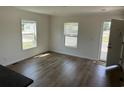 Bright living room with luxury vinyl plank flooring, two windows and a door at 512 King Air Ct, Myrtle Beach, SC 29577