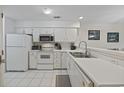 Bright kitchen with white cabinetry, appliances, tile flooring, and stainless steel faucet at 69 Pinehurst Ln. # 3-F, Pawleys Island, SC 29585