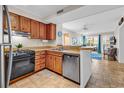 Functional kitchen featuring wood cabinetry, black appliances, and an open breakfast bar overlooking the living room at 9581 Shore Dr. # 127, Myrtle Beach, SC 29572