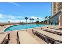 Relaxing pool deck with comfortable lounge chairs, palm trees, and partial view of the beach at 101 Ocean Creek Ocean Creek Dr. # Qq3, Myrtle Beach, SC 29572