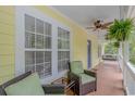 Inviting porch with seating area, ceiling fan, and hanging plants, perfect for relaxing outdoors at 1050 Hagley Dr., Pawleys Island, SC 29585