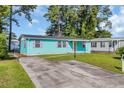 Home featuring teal siding and purple shutters, complemented by an expansive driveway at 1107 Blue Ridge Trail, North Myrtle Beach, SC 29582